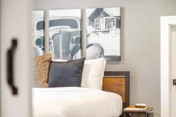 A unique and eclectic bedroom featuring sliding barn doors and vintage car wall decor, creating a one-of-a-kind atmosphere that is both stylish and nostalgic.