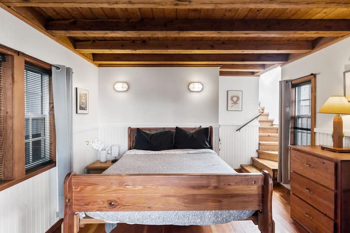 Acogedor dormitorio estilo loft con techos de viga de madera y cálida luz natural