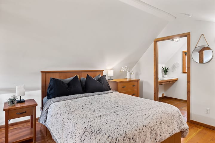 Acogedor dormitorio tipo loft con cálida decoración de madera y tocador privado