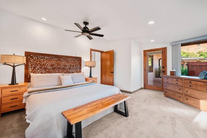 - חדר שינה מרווח עם מיטת קינג סייז וראש מיטה מגולף אמנותי - גישה פרטית לחוץ מחברת אתכם לנוף של סדונה - תאורה מודרנית ואקצנטים מעץ יוצרים מקום מפלט שליו  