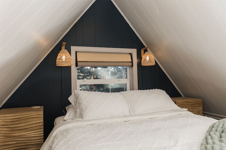 Таванското помещение е разположено с двойно легло, скрин, уютен стол и голяма офис зона.