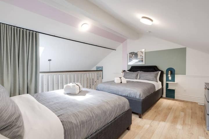 พื้นที่นั่งเล่นเหนือห้องนั่งเล่นพร้อมเตียงขนาดควีนไซส์อันอบอุ่น 2 หลัง