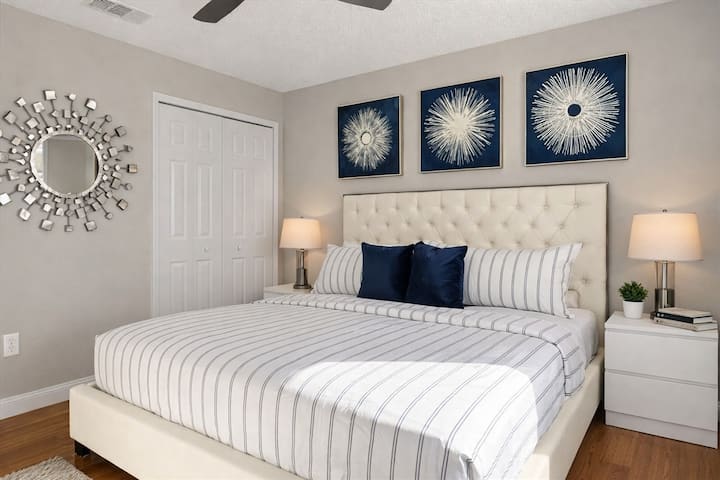 Chambre moderne avec très grand lit, matelas à plateau-coussin et œuvres d'art modernes. 
