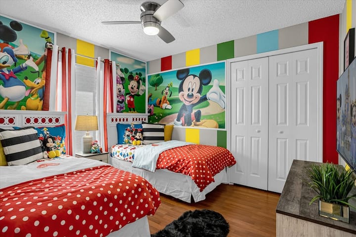 Chambre d'enfant avec deux lits jumeaux sur le thème de Mickey.