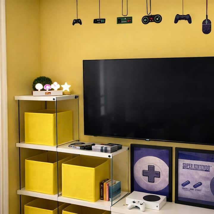 Salle de jeux Mario avec téléviseur intelligent de 50 pouces, Xbox et décor de jeux vidéo.