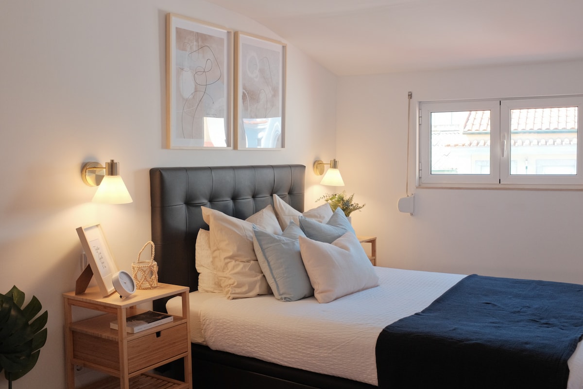 ห้องนอนที่เงียบสงบพร้อมแสงไฟสว่างนุ่มนวล หมอนนุ่มฟู และเสน่ห์ที่อบอุ่น

