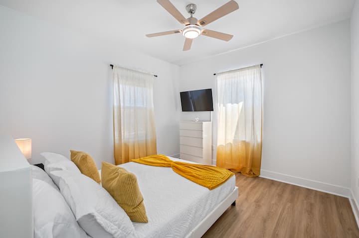 მზით განათებული საძინებელი მეორე სართულზე, რომელშიც არის კომფორტული 152‑179 სმ ზომის საწოლი, რბილი თეთრეული და თბილი ოქროსფერი დეტალები. სტუმრების განკარგულებაშია ჭერზე დამონტაჟებული სმარტ‑ტელევიზორი, კომოდი და ჭერის ვენტილატორი, ხოლო ბუნებრივი სინათლე რამდენიმე ფანჯრიდან შემოდის. მშვიდი და მიმზიდველი საცხოვრებელი, რომელიც იდეალურია დასასვენებლად.