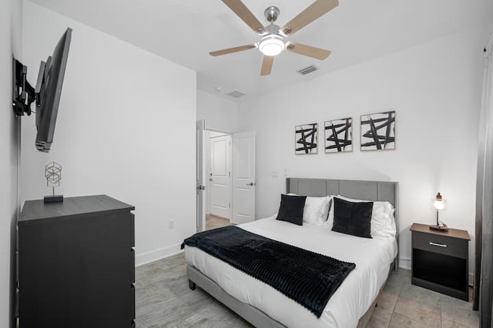 ქვემოთ მდებარე კომფორტული საძინებელი, რომელიც გამოირჩევა ფუფუნების მეფე‑ზომის საწოლითა და თანამედროვე დეკორით. ამ ოთახშია ჭკვიანი ტელევიზორი, კომოდი, საწოლთან განათება, ჭერის ვენტილატორი და დიდი კარადა. მშვიდი და მიმზიდველი სივრცე, რომელიც იდეალურია მშვიდი ძილისთვის.