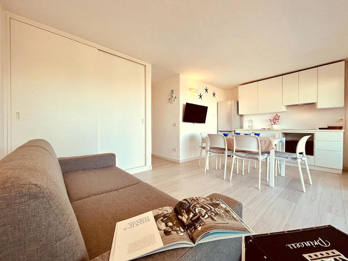 Dhomë ndenjjeje me kuzhinë dhe hyrje në tarracë, e pajisur me:
Divan krevat, dollap, ajër i kondicionuar, televizor, enëlarëse, frigorifer me frigorifer, sobë. 