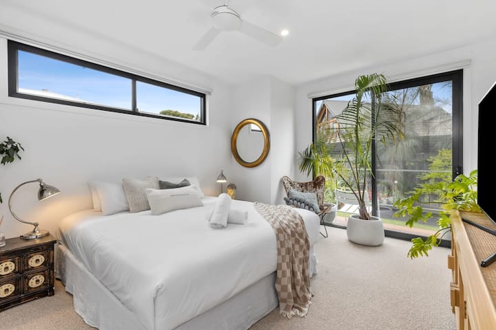 Dormitorio king en la planta baja con TV inteligente y acceso privado al balcón del jardín 