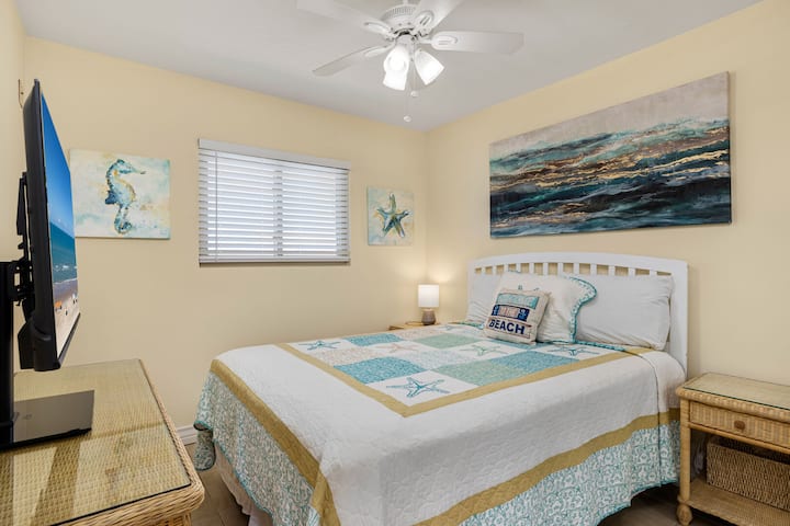 ผ่อนคลายในห้องนอนหลักที่สะดวกสบายของคุณ มีเตียงควีนไซส์และทีวีจอแบน