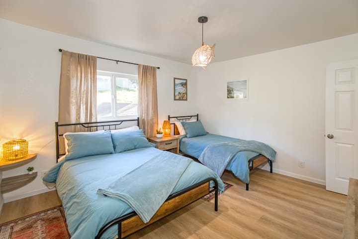 Dormitorio más pequeño de la Unidad 2 con camas tamaño queen y dos camas individuales. Está frente a una calle tranquila