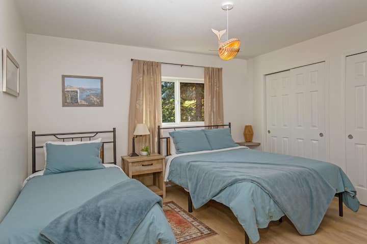 Dormitorio más pequeño de la Unidad 1 con cama tamaño queen y camas individuales. Está frente a una calle tranquila.