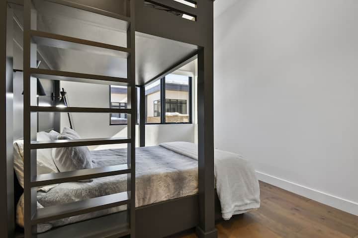 Chumba cha kisasa cha ghorofa kilichobuniwa mahususi chenye vitanda vikubwa na samani za ndani za kisasa.