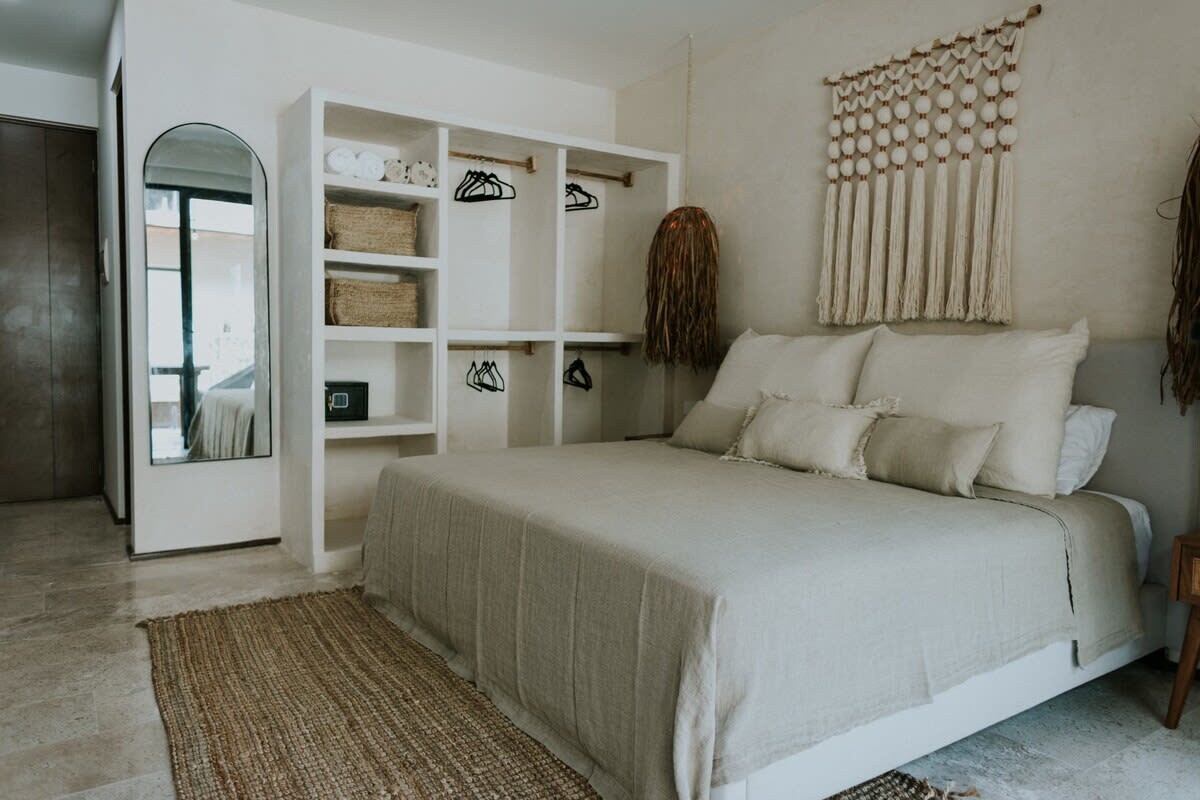 Chumba kikubwa cha kulala chenye bafu lake, runinga, kabati, roshani na chumba cha kupikia