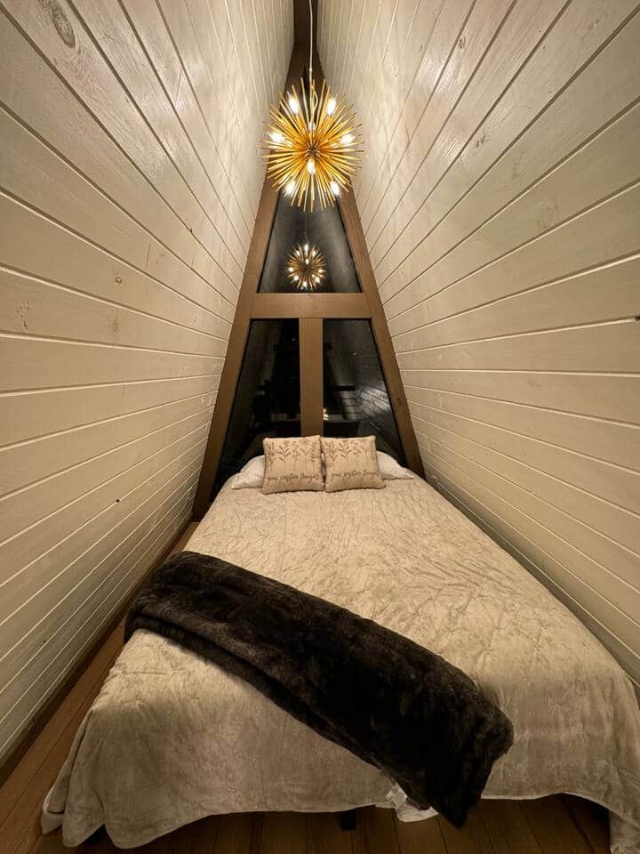 Cama tamaño queen loft por la noche. La luz estelar está en un atenuador para garantizar la iluminación perfecta cuando te relajas para dormir.