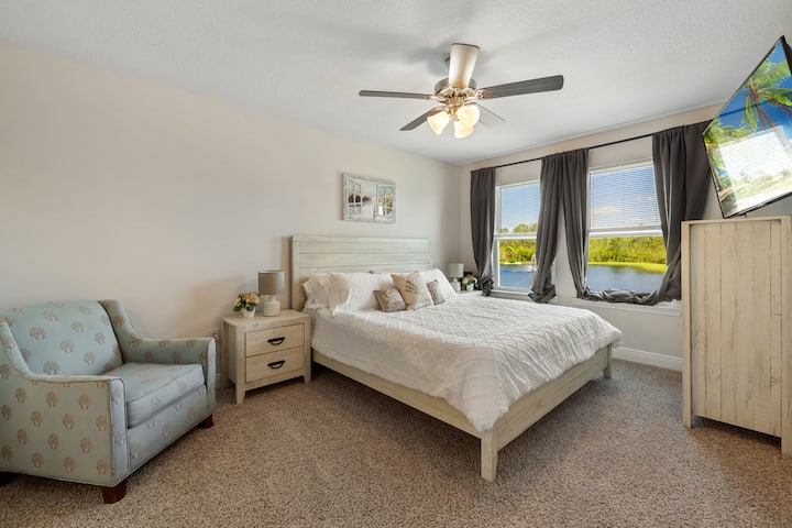 غرفة نوم رئيسية بسرير كبير وتلفزيون.