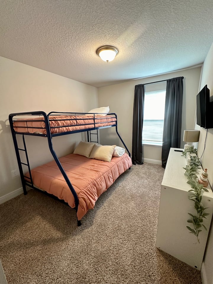 غرفة الضيوف رقم2 التي تحتوي على سرير مزدوج بطابقين كاملين وخزانة وتلفزيون ذكي.