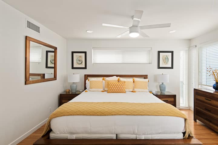 Elegant stort sovrum med en king size-säng, havsinspirerad inredning och eget badrum