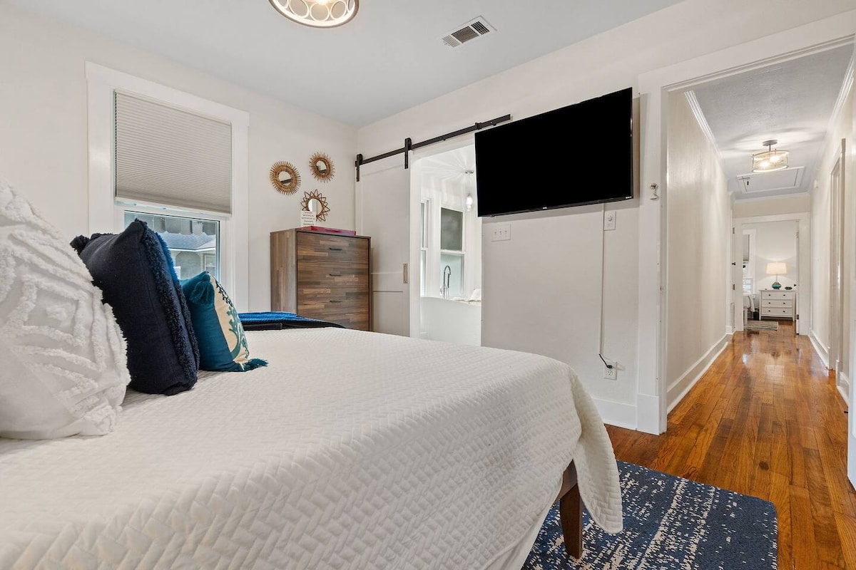 Spacious master suite features 50-inch TV, ensuite luxury bathroom, and premium bedding for multigenerational family comfort.