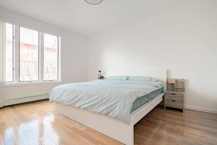Bedroom with two windows and hardwood floors