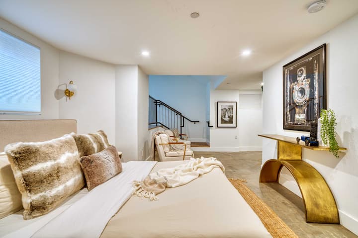 Bed in an open area beside the stairway and console table.