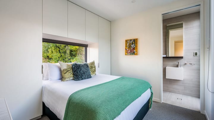 Das vierte Schlafzimmer bietet ein luxuriöses Kingsize-Bett, ein eigenes Bad mit modernen Armaturen und ein ruhiges Ambiente, was es zum perfekten Rückzugsort für ultimative Entspannung macht.