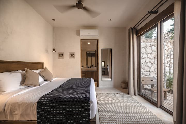Dormitorio en la planta principal, con baño privado, espacio de trabajo y acceso privado al aire libre.
