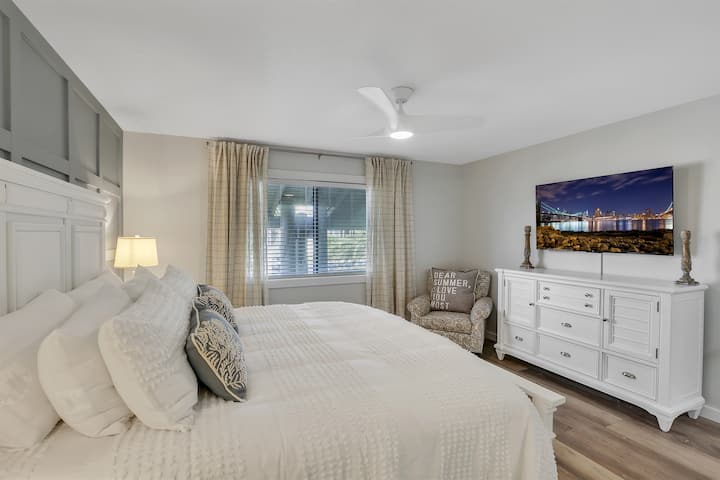 พักผ่อนในห้องสวีทหลักที่มีเตียงคิงไซส์นุ่ม สมาร์ททีวี และการตกแต่งที่ให้ความรู้สึกสงบสำหรับค่ำคืนที่ผ่อนคลายหลังจากใช้เวลาทั้งวันภายใต้แสงแดด