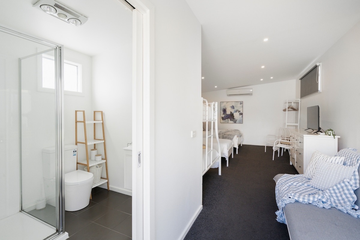 جناح صغير يحتوي على حمام مع دش ومرحاض وخزانة مع مرآة