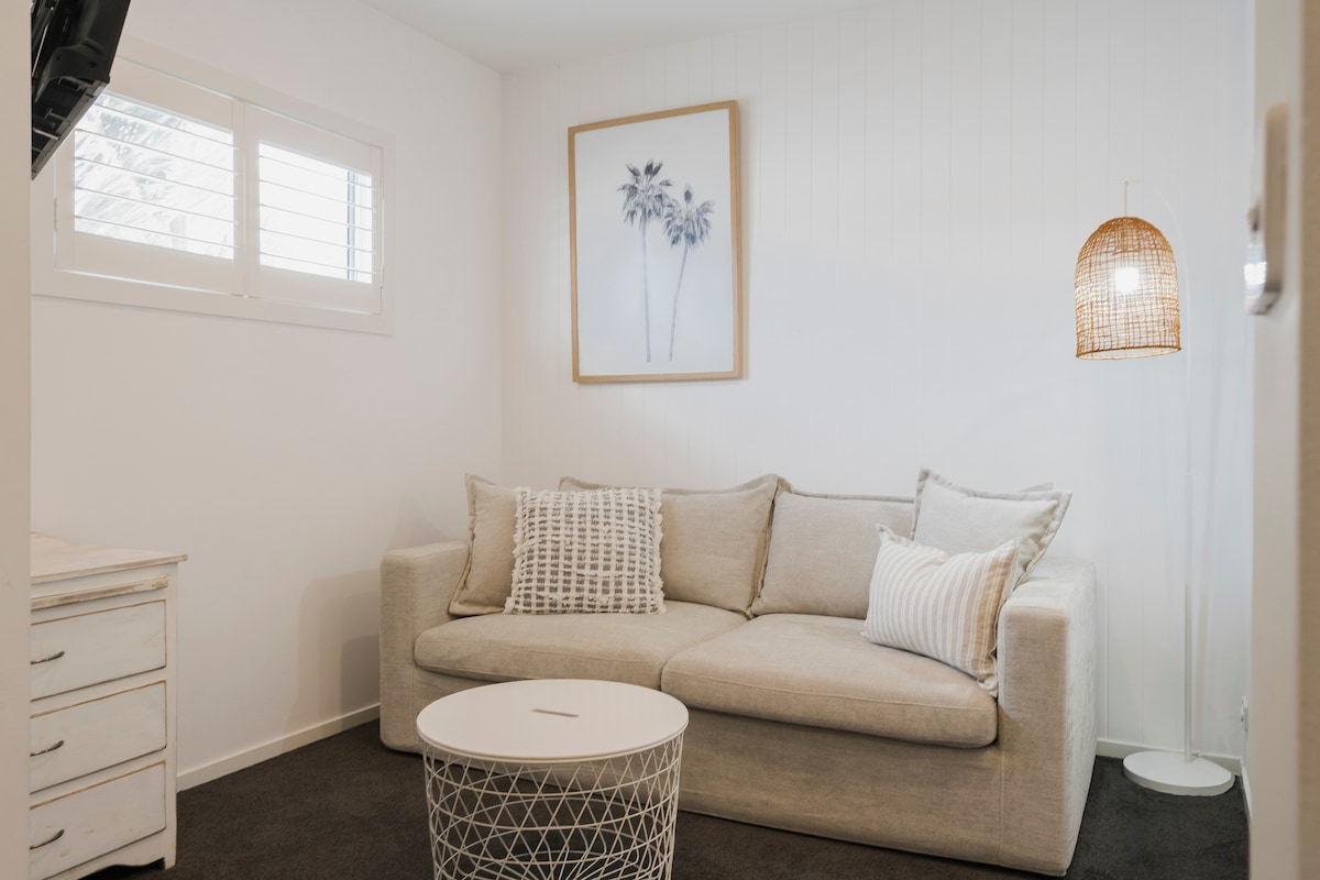 منطقة الطابق العلوي مع تلفزيون وسرير أريكة بحجم كوين