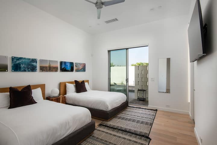 The Twin Bedroom offers two comfortable beds, stylish decor, and direct access to a quiet outdoor patio area.