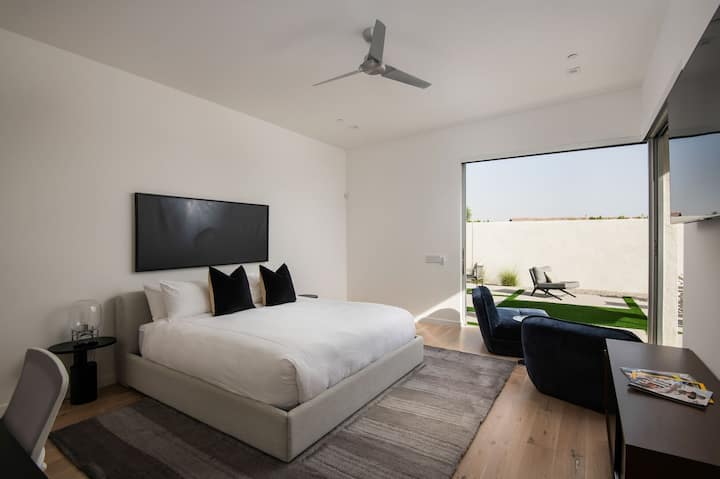 क्वीन बेड, बैठने की जगह, बड़े स्मार्ट टीवी और बैक पैटियो तक जाने के लिए निजी स्लाइडिंग डोर ऐक्सेस के साथ शानदार प्राइमरी सुईट।