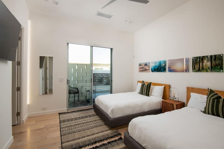 El dormitorio doble flexible está bellamente diseñado con arte contemporáneo y ofrece acceso directo a un patio privado y cerrado.