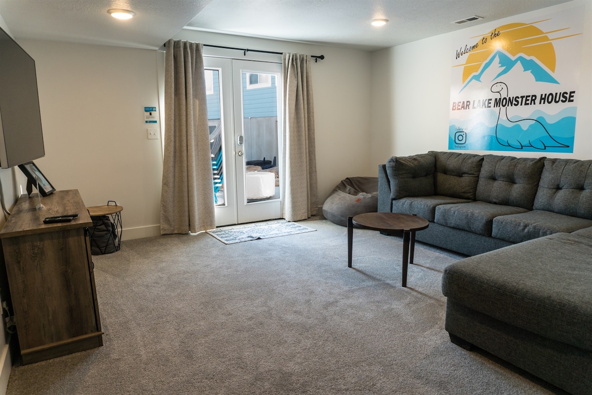 Basement common area featuring a full-size pull-out bed, a bean bag chair, and walk-out entrances.