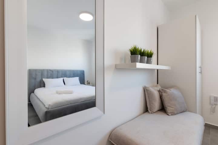 გონივრულად მოწყობილი სარკის კუთხე, რომელიც ასახავს ფართო სივრცესა და კარგად მოფიქრებულ ინტერიერის დიზაინს.