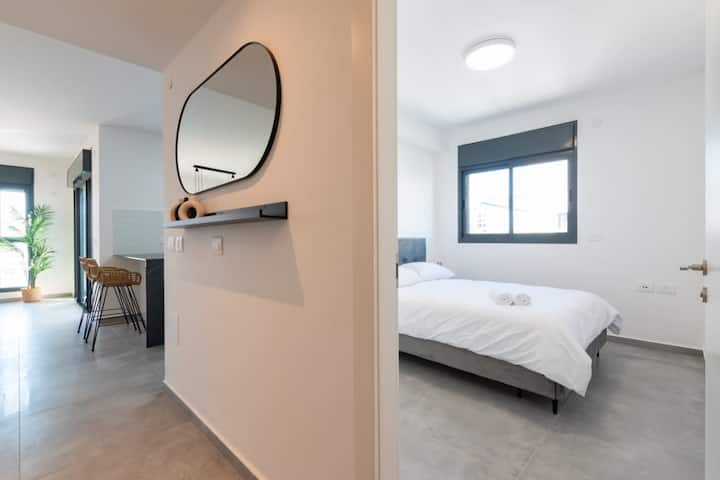 ღია დერეფნის ხედი, რომელზეც ხაზგასმულია თავისუფალი გადაადგილების შესაძლებლობა და საცხოვრებელი სივრცეების გააზრებულად მოწყობა.