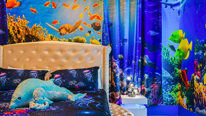 Წყალქვეშა თემატიკის ოთახი ძლიერი ოკეანის ფრესკებითა და მყუდრო წყლის თეთრეულით.