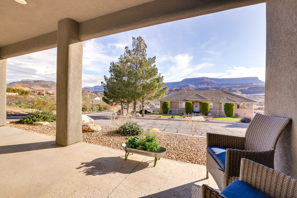 A shared front patio area features comfortable outdoor seating, complemented by a small table and decorative plants. Views of the surrounding landscape and nearby mountains are visible, creating a serene atmosphere. The concrete flooring adds a functional touch to the outdoor space.