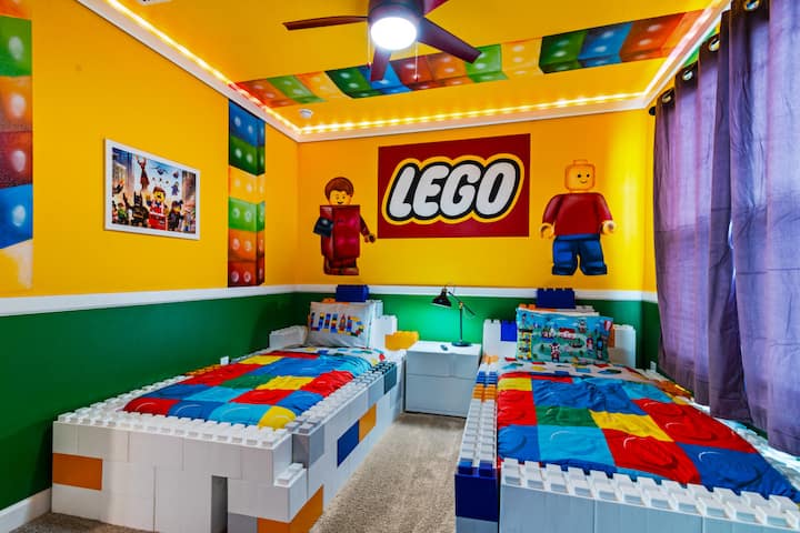 - غرفة نوم مستوحاة من LEGO مع أسرّة كتل ملونة - جداريات مشرقة وإضاءة مرحة علوية - أسرّة مزدوجة مع مفارش ذات طابع خاص للأطفال  