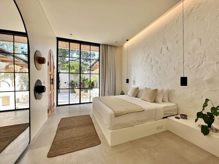 Спалня с голямо двойно легло и изглед към градината