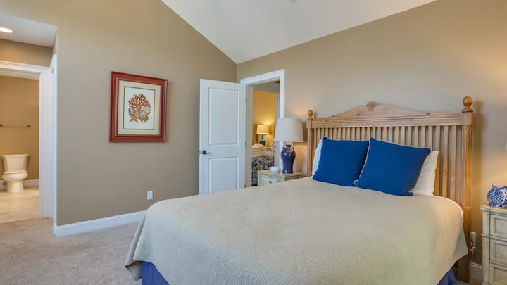 Оваа светла спална соба на горниот кат има заоблени тавани, многу природна светлина и мирни погледи низ прекрасен заоблен прозорец.