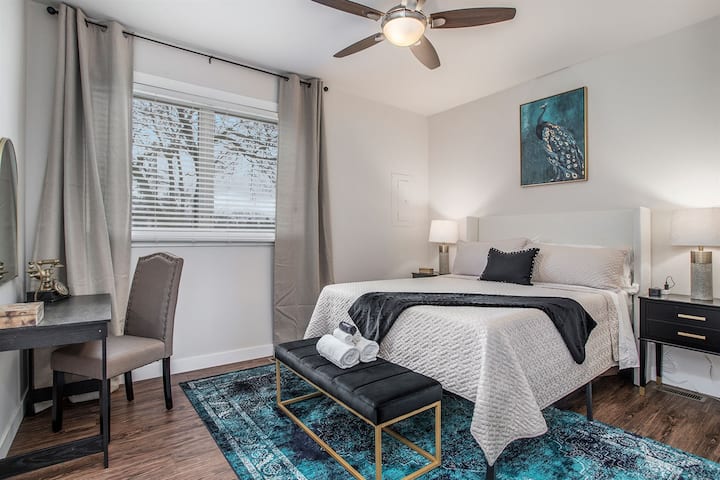 Experience a cozy and indulgent stay in our elegantly designed queen bed. The accompanying black desk, paired with a luxurious gold mirror, offers the ideal space for both work and getting ready for the day.