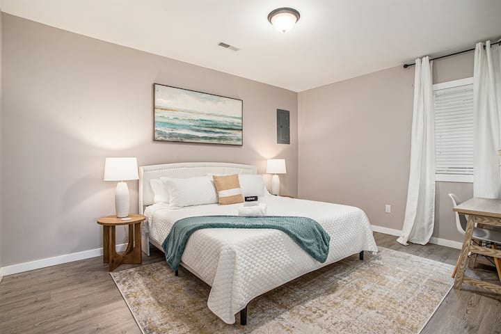 Our spacious king bed features a plush white comforter, ensuring a restful night's sleep. The accompanying desk is perfect for catching up on work or planning your day, while ample closet space provides room for your belongings.
