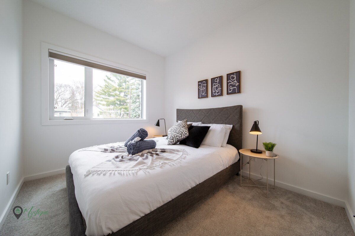 Dormitorio con cama tamaño queen y armario con persianas oscuras en la habitación