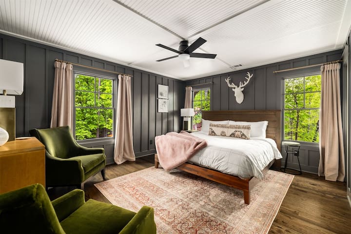 Habitación “Woodlands” con cama KING y BAÑO PRIVADO: un oasis privado en las copas de los árboles, equipada con cortinas de terciopelo y un par de cómodos sillones club de terciopelo, perfecta para conversaciones nocturnas o para relajarse en tranquilidad.