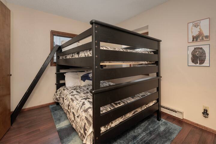 A tus hijos les encantará esta acogedora habitación con literas y estampados con motivos de la naturaleza que adornan las paredes.