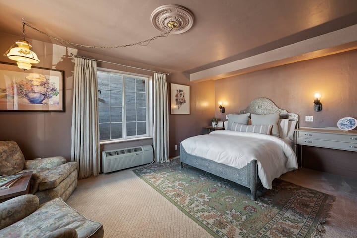 Spring bedroom includes a sitting area and a queen bed