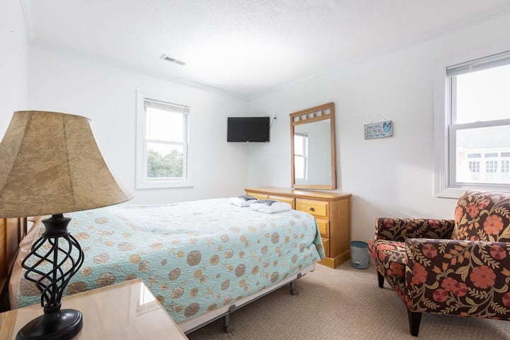 Habitación luminosa con cama doble tamaño queen para una estancia relajante