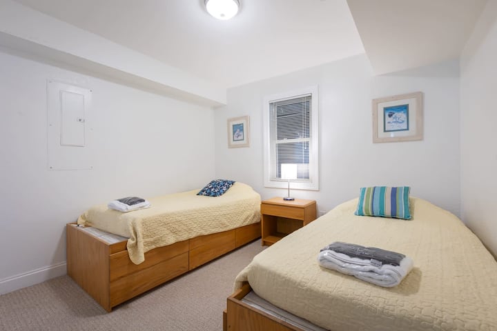 Dormitorio con dos camas individuales y baño privado compartido
